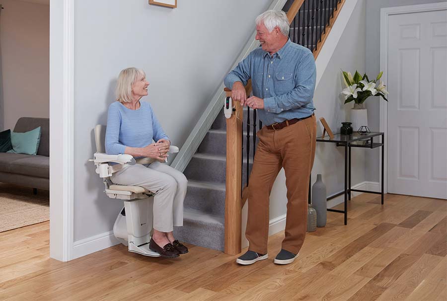 eldery couple next to stairs with stairlift